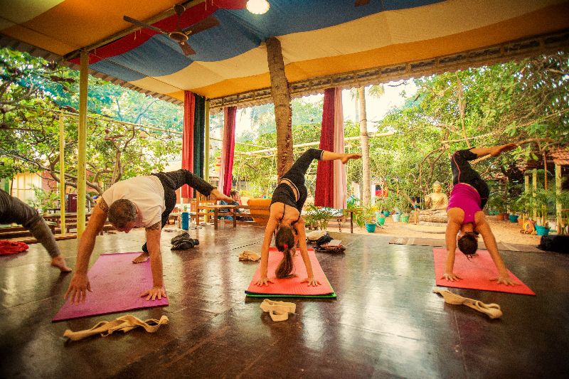 A group of people doing yoga in a room.